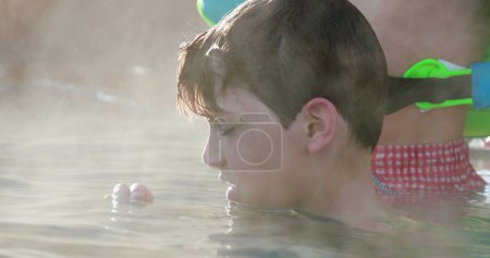 Foto de Niño dentro de agua caliente de la piscina, agua caliente evaporándose - Imagen libre de derechos