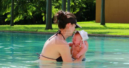 Foto de Mother and infant crying newborn at the swimming pool - Imagen libre de derechos
