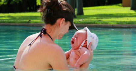 Foto de Mother and newborn at the swimming pool crying displeased - Imagen libre de derechos