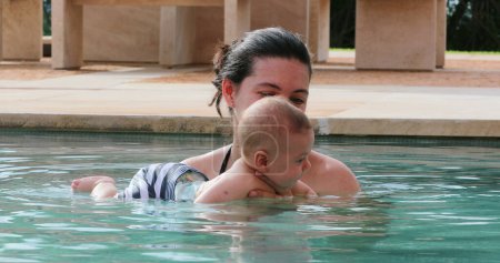 Téléchargez les photos : Happy mother with newborn baby son at the swimming pool water - en image libre de droit