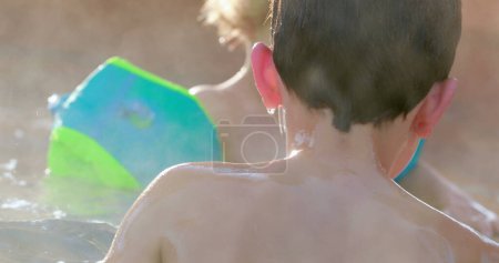 Téléchargez les photos : Enfants dans l'eau chaude de la piscine - en image libre de droit
