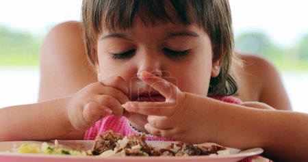 Photo for Messy little girl eating meal with hands - Royalty Free Image