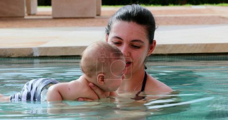 Téléchargez les photos : Newborn baby inside swimming pool water with mother - en image libre de droit