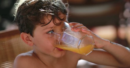 Foto de Niño pequeño bebiendo jugo de naranja - Imagen libre de derechos