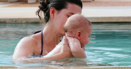 Foto de Mother and newborn baby infant son together at the swimming pool water - Imagen libre de derechos