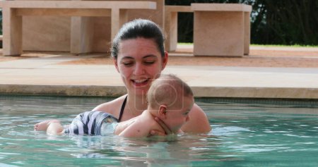 Foto de Mother and newborn baby infant son together at the swimming pool water - Imagen libre de derechos