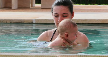 Téléchargez les photos : Mother and newborn baby infant son together at the swimming pool water - en image libre de droit