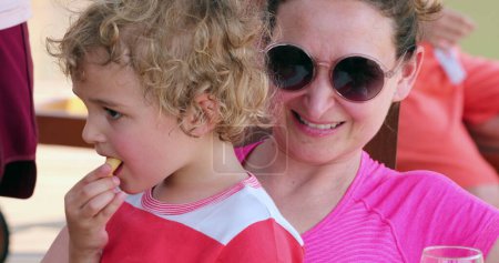 Téléchargez les photos : Mère et enfant fils accrochés ensemble dehors dans la vraie vie franche moment de famille - en image libre de droit