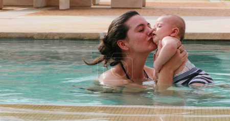 Photo for Happy loving young mother at the swimming pool water with newborn baby infant son - Royalty Free Image