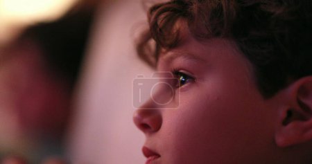 Téléchargez les photos : Jeune garçon regardant l'écran de télévision, enfant candide occasionnel hypnotisé par l'écran - en image libre de droit