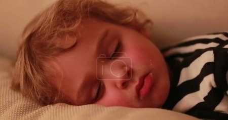 Téléchargez les photos : Young boy sleeping at night, close-up of baby face asleep in sofa - en image libre de droit