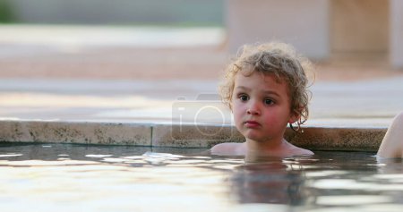 Téléchargez les photos : Enfant en bas âge à l'intérieur de l'eau de piscine - en image libre de droit