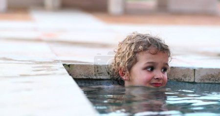 Photo for Child inside swimming pool water hiding face - Royalty Free Image