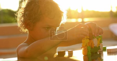 Foto de Small boy playing with toys in the sunlight outdoors - Imagen libre de derechos
