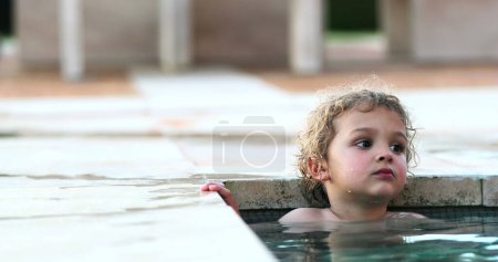 Candid child inside swimming pool water relaxing