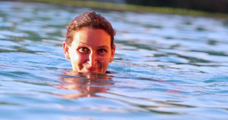Foto de Feliz mujer divertida nadando hacia la cámara disfrutando de las vacaciones de verano sonriendo - Imagen libre de derechos