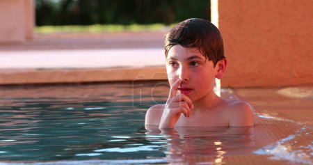 Foto de Candid niño reflexivo en la piscina - Imagen libre de derechos