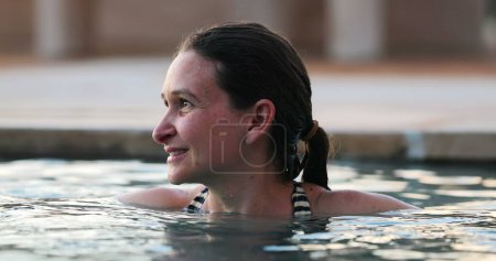 Téléchargez les photos : Femme franche décontractée à l'intérieur de l'eau de piscine relaxante - en image libre de droit