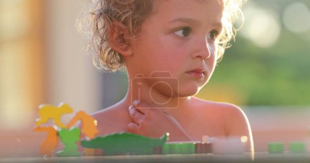 Photo for Toddler boy thinking trying to figure out puzzle - Royalty Free Image