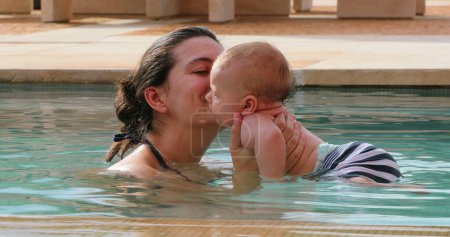 Photo for Happy mother with newborn baby in swimming pool water - Royalty Free Image