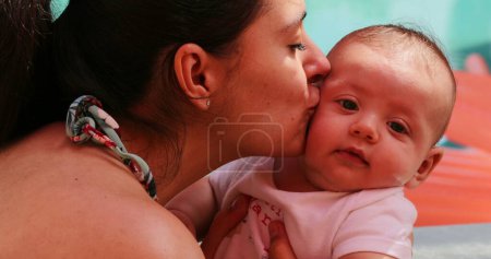 Foto de Mother kissing newborn baby showing love and affection - Imagen libre de derechos