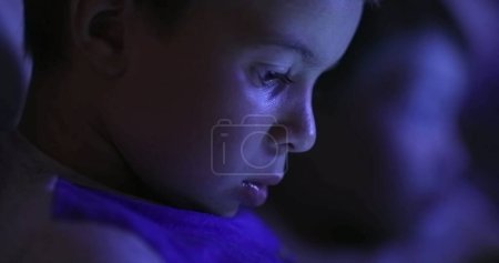 Photo for Young boy in front of Tablet screen, blue light - Royalty Free Image