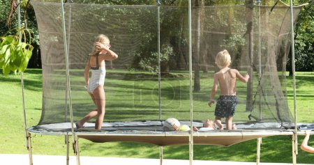 Foto de Niños saltando dentro del trampolín al aire libre - Imagen libre de derechos