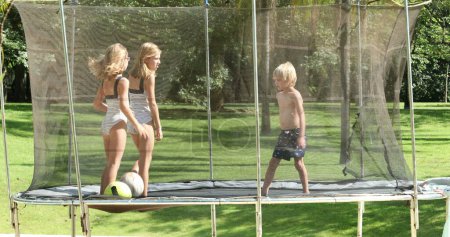 Téléchargez les photos : Enfants à l'intérieur trampoline debout dehors - en image libre de droit