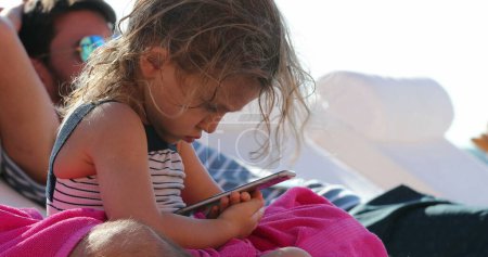 Little girl child looking at cellphone device screen