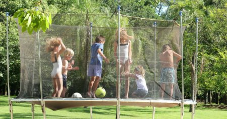 Téléchargez les photos : Beaucoup d'enfants sautant de haut en bas à l'intérieur du trampoline - en image libre de droit