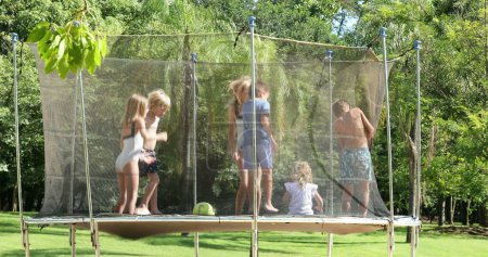 Photo for Many children jumping up and down inside trampoline - Royalty Free Image