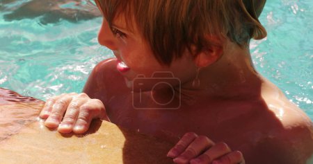 Photo for Young boy holding into swimming poolside - Royalty Free Image