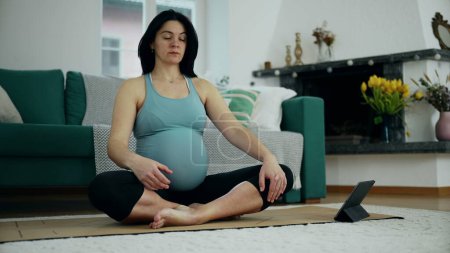 Photo for Pregnant woman meditating at home living room floor in serene pose in deep contemplation, taking care of mental health and mindfulness - Royalty Free Image
