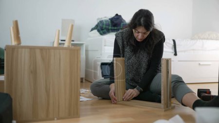 Photo for Home Improvement Enthusiast Woman Crafting Nightstand, Showcasing DIY Skills in Furniture Assembly for Home Setup, Capturing the Essence of Moving to a New House - Royalty Free Image