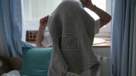 Petit garçon mettant pull debout dans la chambre. 5 ans caucasien garçon habiller par lui-même vêtements vêtements chauds pendant la saison froide