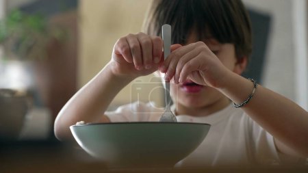 Délice des spaghettis - Petit garçon essayant de faire tourner la fourchette en mangeant de la nourriture pour pâtes pendant les repas. Enfant appréciant apprendre à utiliser des ustensiles