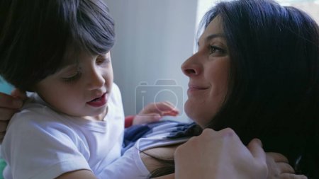 Photo for Loving home scene of child and mother in gentle embrace. Authentic real life mom and son hug in love and affection - Royalty Free Image