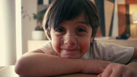 Téléchargez les photos : Engager le jeune garçon dans un moment naturel - Sourire de cinq ans aux yeux brillants et à l'expression curieuse - en image libre de droit