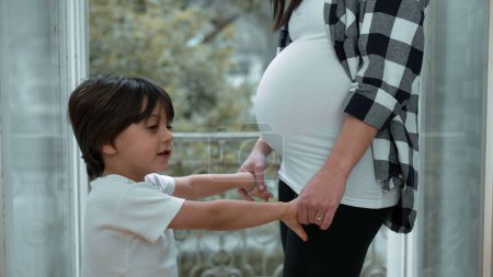 Small Boy Embracing Expectant Mother's Belly by Balcony, Tender Affection for Unborn Sibling