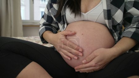 Foto de Mujer embarazada acaricia bebé nonato, primer plano hant suavemente tocando el vientre del tercer trimestre - Imagen libre de derechos