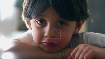 Photo for One small boy shrugging shoulders displaying doubt while in deep mental reflection, close-up face of contemplative kid indifferent to solution - Royalty Free Image
