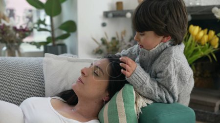 Photo for Son Caresses Mother While She Rests on Couch at Home, Embodying a Tender Family Relationship Bond - Royalty Free Image