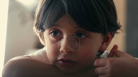 Portrait d'un petit garçon pensif regardant dans une rêverie réfléchie, gros plan sur le visage d'un garçon caucasien de 5 ans, perdu dans la pensée