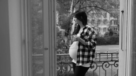 Photo for Expectant Mother Relishing Quiet Tea Time on Urban Balcony, Serene Cityscape in Pregnancy's Late Stage in black and white - Royalty Free Image