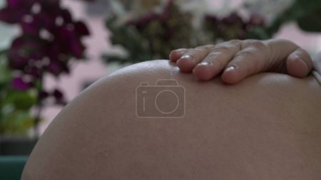 Foto de Brillo expectante: primer plano de la mujer embarazada acariciando su vientre, irradiando anticipación y alegría por la nueva vida que crece en su interior - Imagen libre de derechos