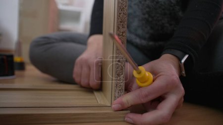 Primer plano mano armando muebles, configuración de bricolaje. Persona colocando dos piezas de madera juntas. mudanza al nuevo concepto de hogar