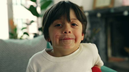 Téléchargez les photos : Jeune garçon de 5 ans portrait assis à la maison canapé, gros plan du visage joyeux garçon caucasien - en image libre de droit
