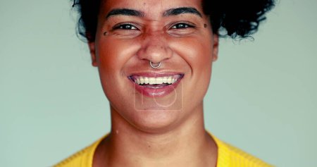Foto de Una joven y feliz mujer afroamericana de cerca sonriendo y riendo, auténtica expresión de la vida real de una persona brasileña reaccionando al comentario divertido - Imagen libre de derechos
