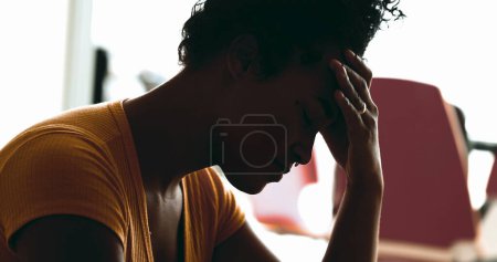 Foto de Joven mujer afroamericana lucha con la depresión en casa en la desesperación tranquila sentirse abrumado por el estrés y el dolor poniendo las manos en las sienes laterales sintiendo dolor de cabeza - Imagen libre de derechos