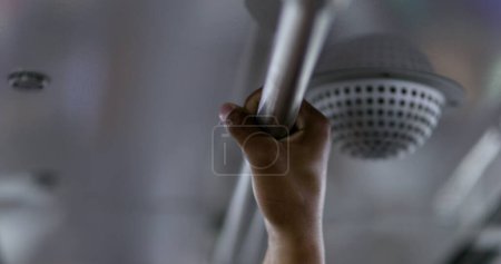 Close-Up of Hand Gripping Metal Bar in Public Transportation, person riding underground metro subway prudently holding bar